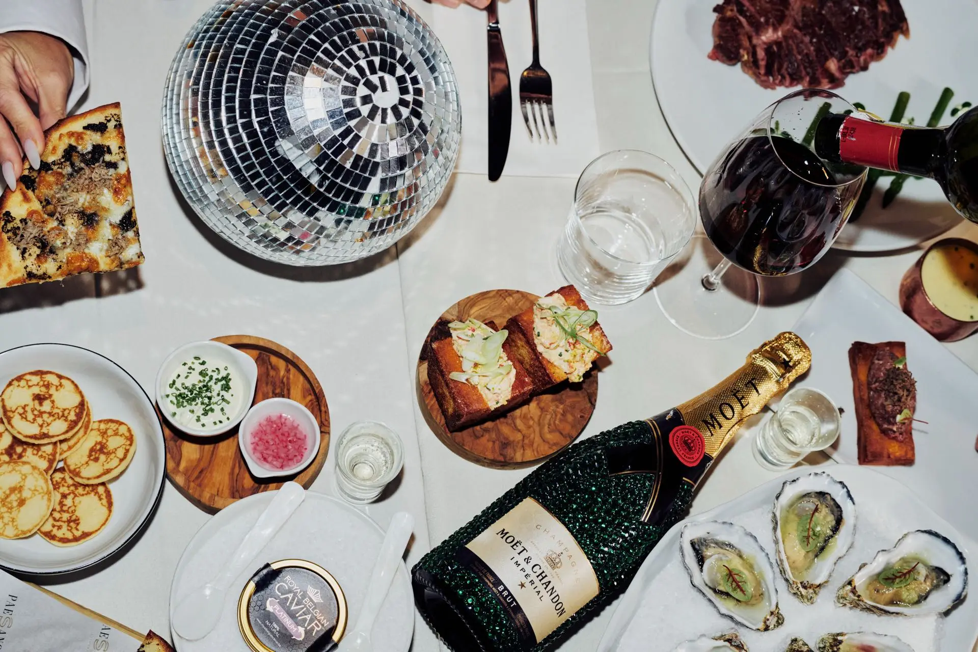 Overvloedige tafel met champagne en Italiaanse gerechten bij Paesano